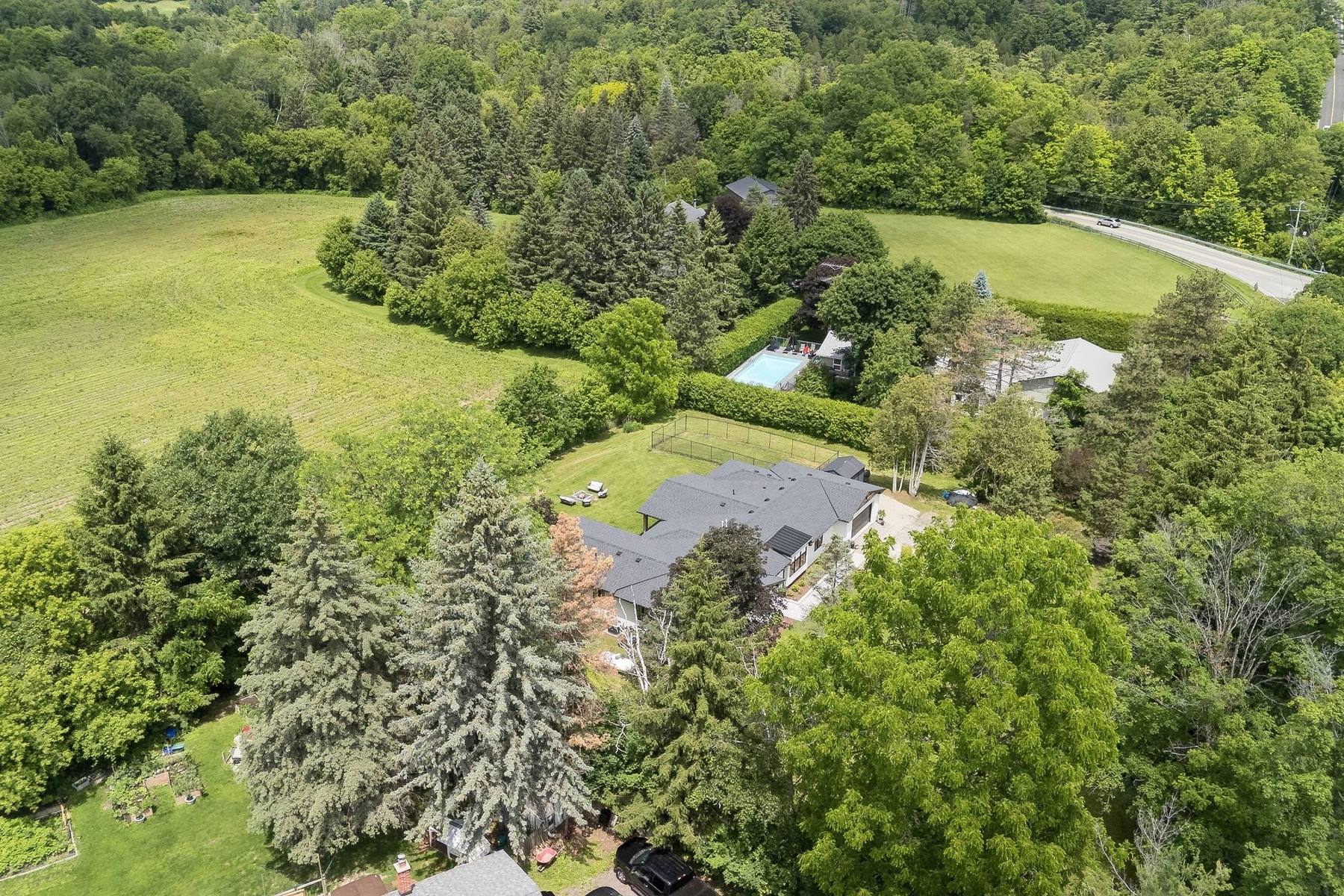 Aerial view of the property surrounded by open farmland and forest